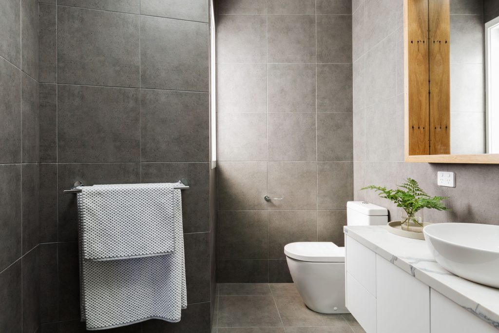 75761268 - charcoal grey modern bathroom with marble benctop and wood mirror