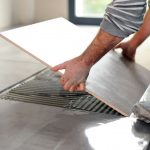 23874071 - man laying floor tiles